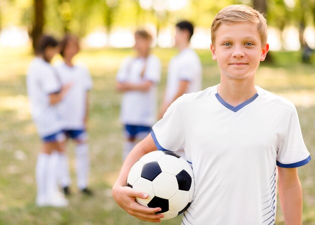 Little boy posing with a football outdoors