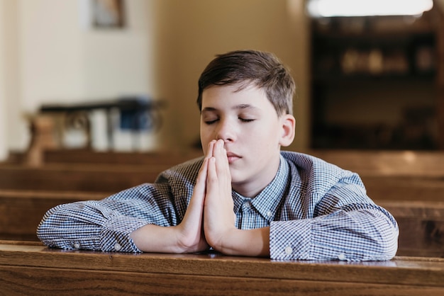 Little boy praying in the church