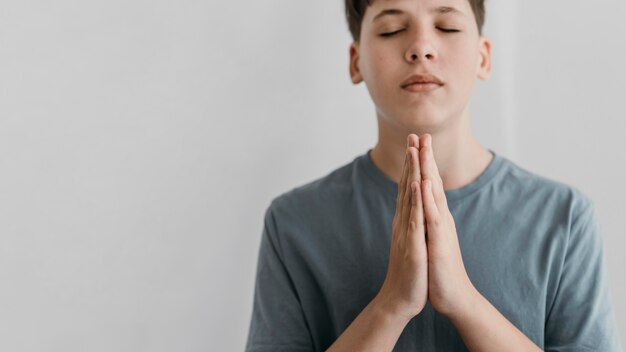 Little boy praying with copy space