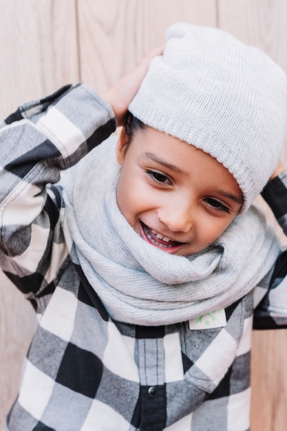 Free Photo little boy putting on winter cap 