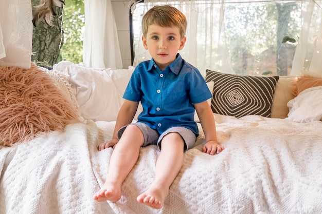 Little boy sitting in his caravan's bad