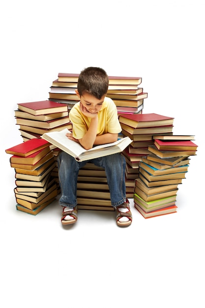 Little boy sitting on large stack of books