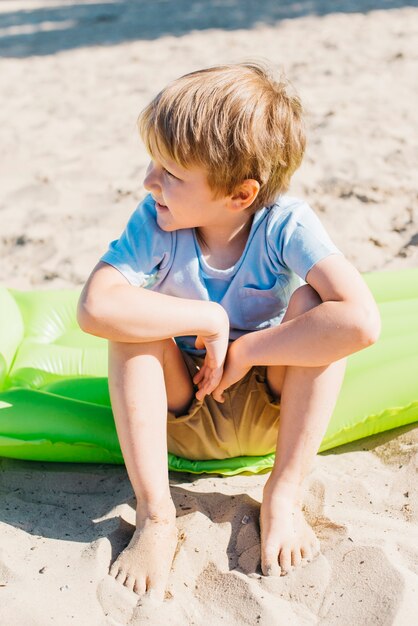 Little boy sitting on sand