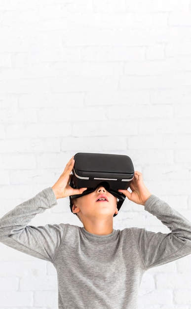 Free photo little boy using virtual reality glasses