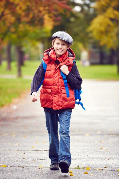 Little boy walking to school with backpack