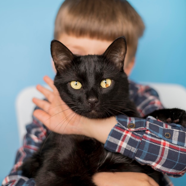 Free Photo little boy with black cat