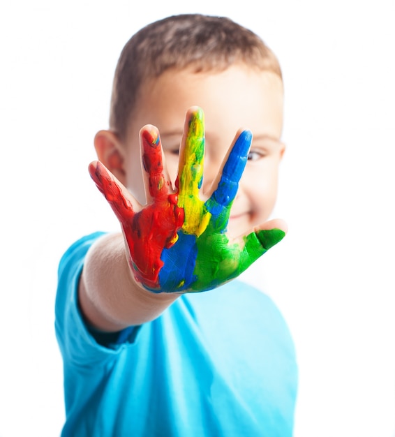 Free photo little boy with a hand full of paint covering his face