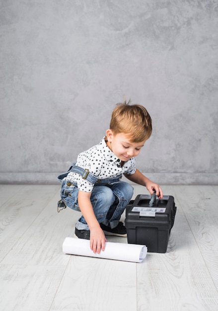 Little boy with tool box and paper roll