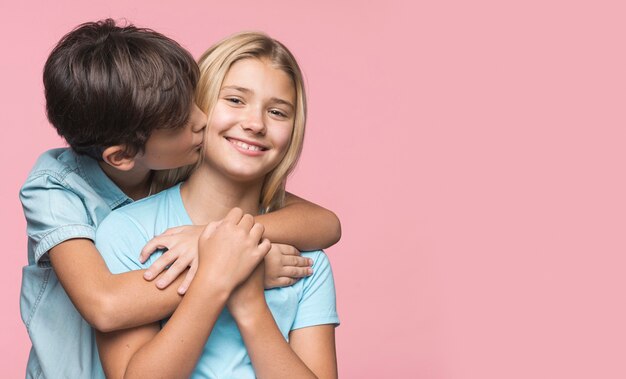 Little brother kissing sister on cheek