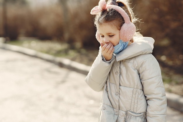 Little child walks outside in a mask