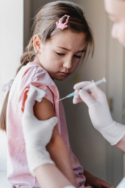 Free photo little child with doctor getting a vaccine