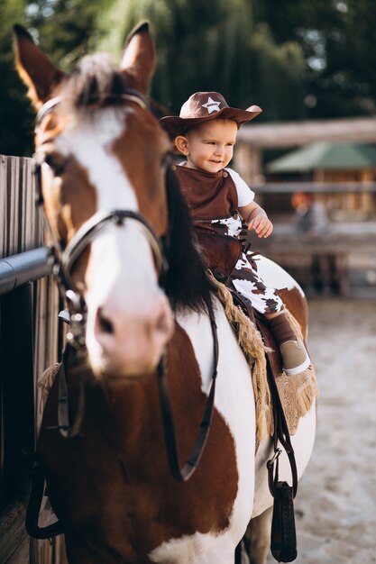 Little cowboy sitting on a horse