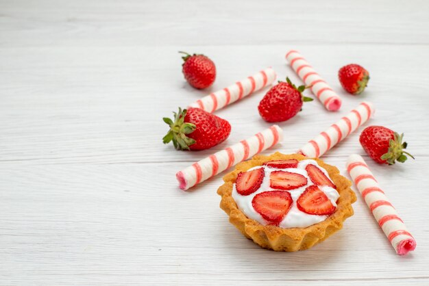 little creamy cake with fresh strawberries and candies on light,  cake sweet fruit berry bake