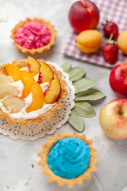 little creamy cake with sliced fruits and white cream along with creamy cakes and fruits on light desk, fruit cake biscuit cookie sweet