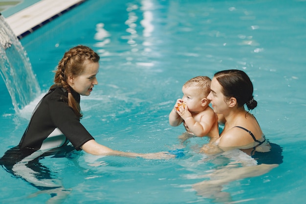 Little cute baby boy. Instructor with kid. Mother with son