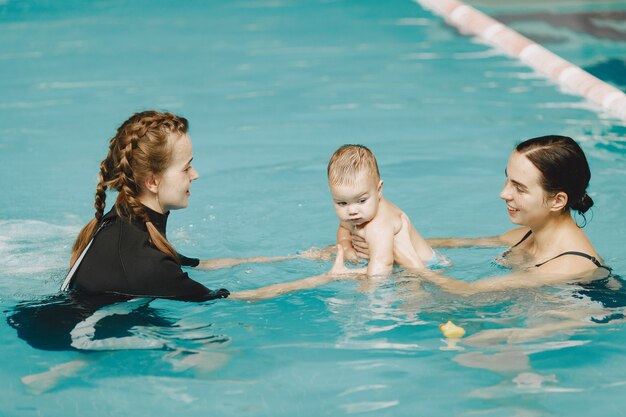 Little cute baby boy. Instructor with kid. Mother with son