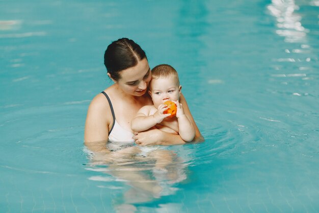 Little cute baby boy. Mother with son. Family playing in a water