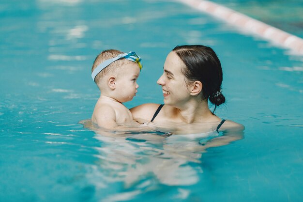 Little cute baby boy. Mother with son. Family playing in a water