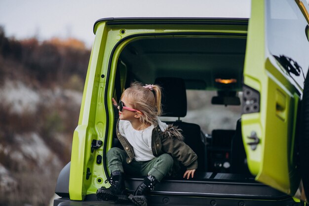 Free Photo little cute baby girl sitting in the back of the car