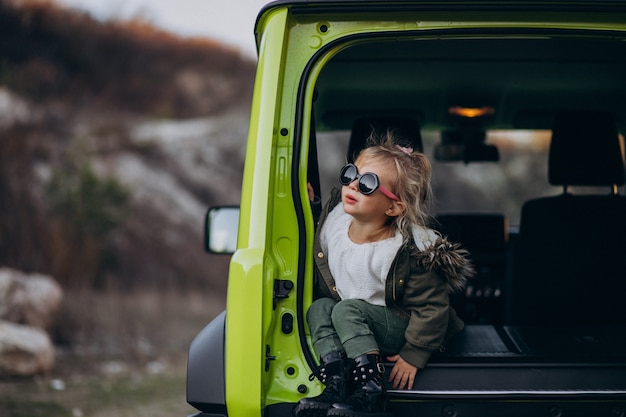 Little cute baby girl sitting in the back of the car