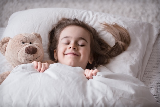 Free photo little cute girl in bed with toy