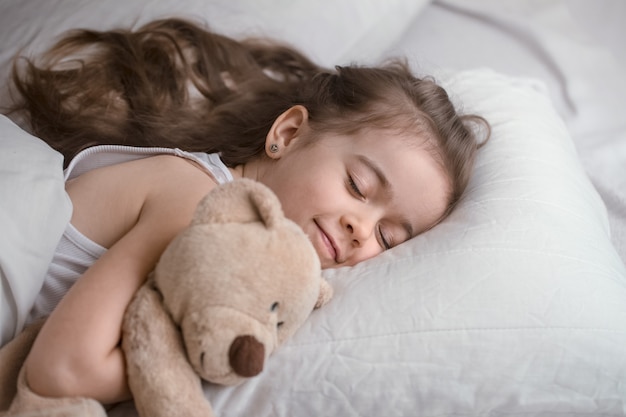 Free photo little cute girl in bed with toy