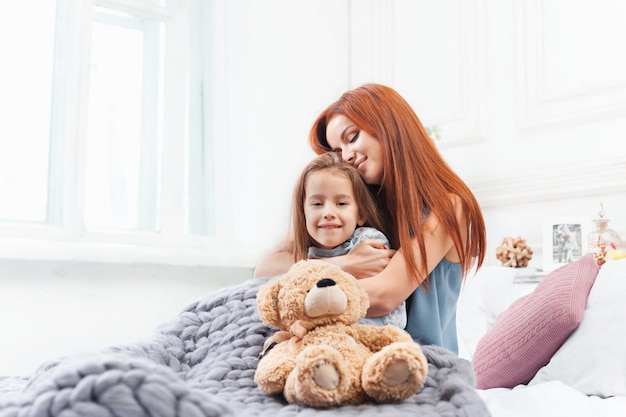 Free photo a little cute girl enjoying, playing and creating with toy with mother