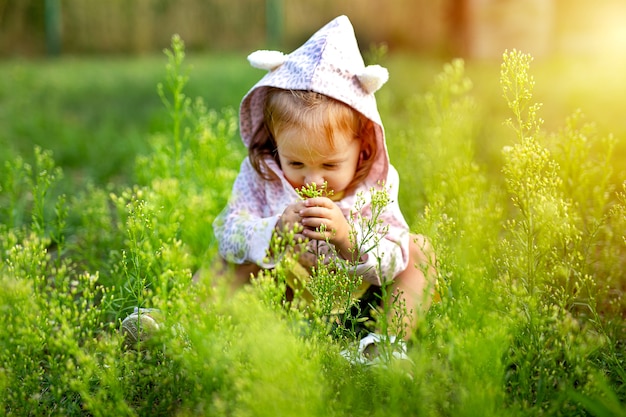 Little cute girl playing on the field of grass