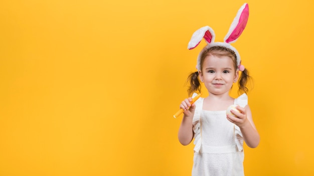 Little girl in bunny ears with egg and felt pen