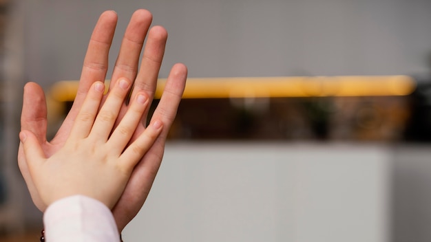 Little girl comparing hand with her father's