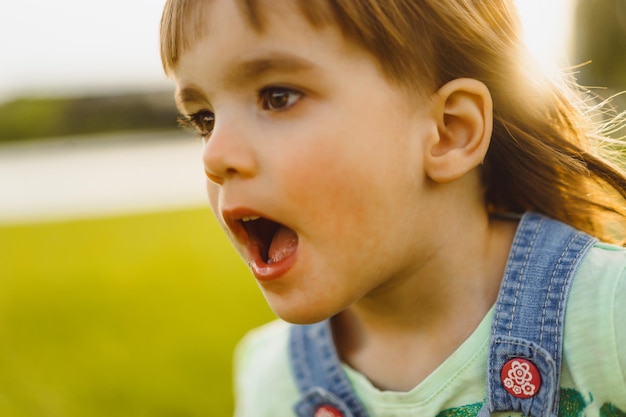 Free Photo little girl on a dandelion field, at sunset, emotional happy child.