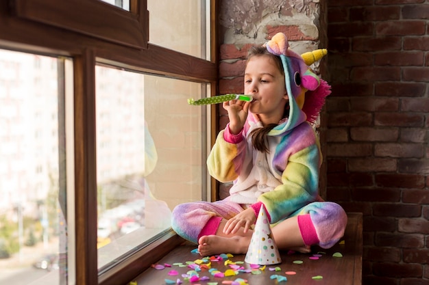 Little girl in dinosaur suit at home during quarantine