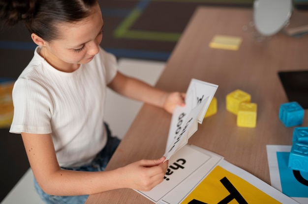 Free photo little girl doing speech therapy at a clinic