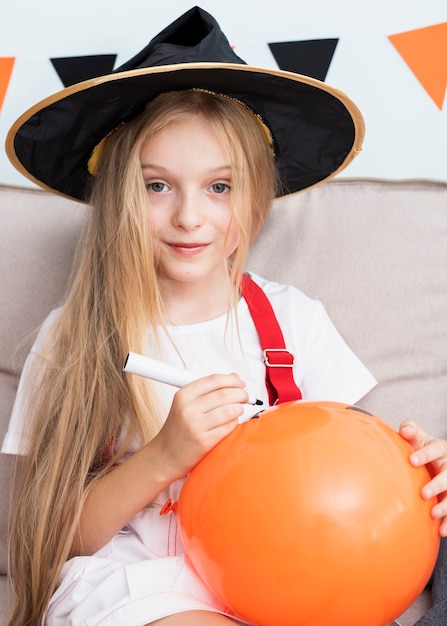 Little girl drawing a halloween baloon