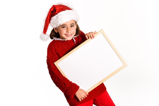 Little girl dressed as santa claus holding a white board