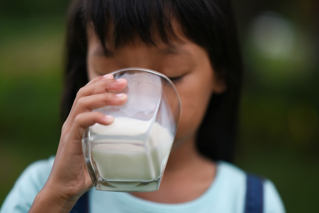 Little girl drinking milk in the park