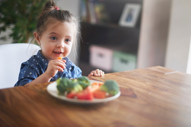 Little girl eating vegetables