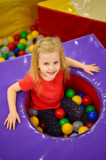 Free photo little girl enjoying ball pit