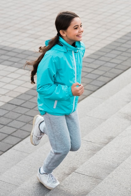 Free photo little girl exercising on stairs