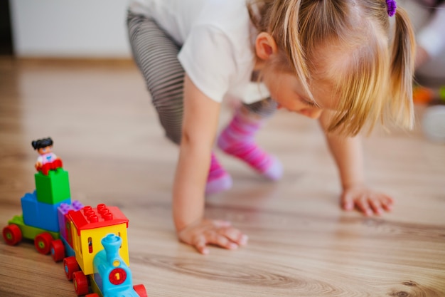 Free photo little girl on floor with toys