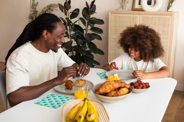 Free photo little girl having breakfast with her father