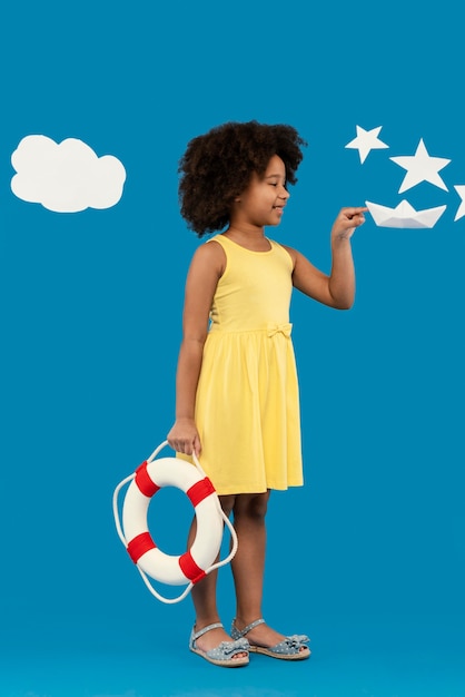 Little girl having fun in a summer setting studio