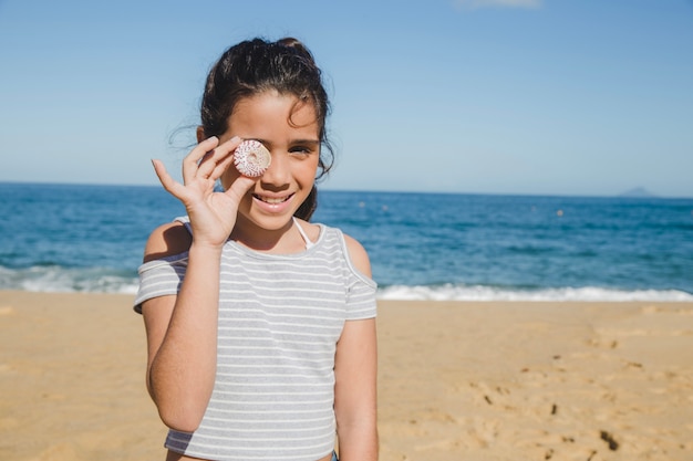 Little girl having fun with a seashell