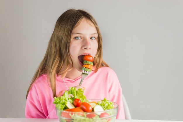 Little girl having healthy breakfast against white background