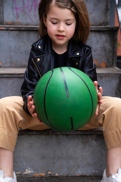 Little girl holding green ball front view