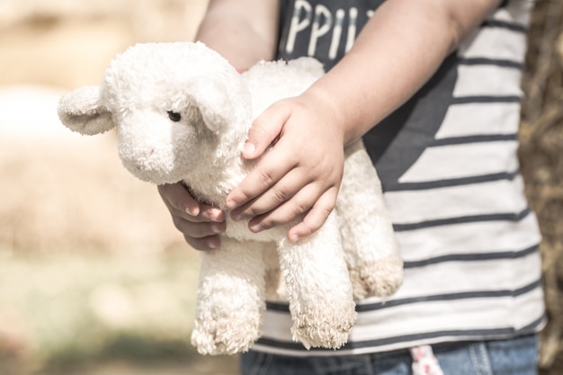 little girl holding a toy sheep