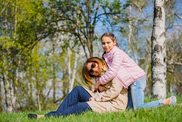 Little girl hugging her mother in the park