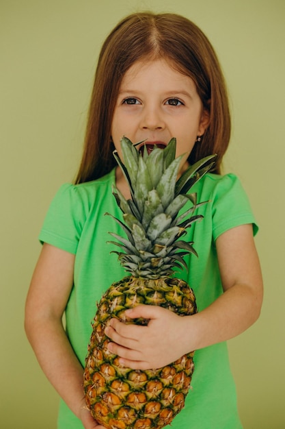 Little girl isolated holding pineapple