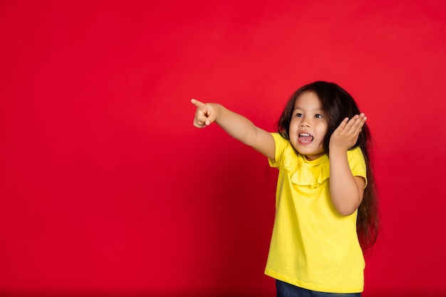 Little girl isolated on red, happy