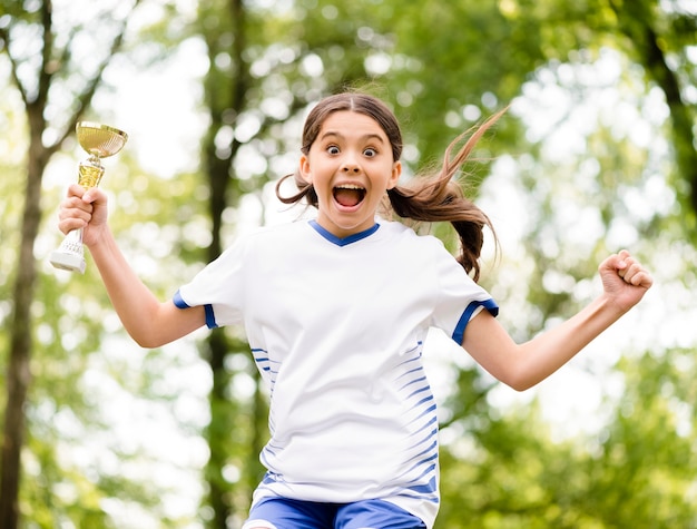 Little girl jumping after winning a football match